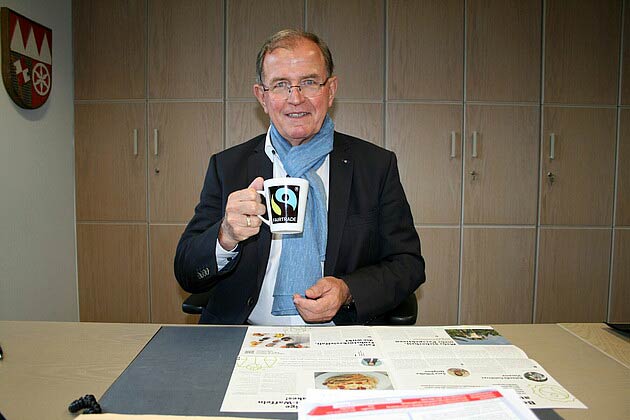 Bezirkstagspräsident Erwin Dotzel mit einer Tasse fair gehandeltem Kaffee